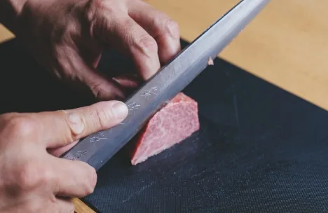 包丁で霜降り和牛を切り分ける様子