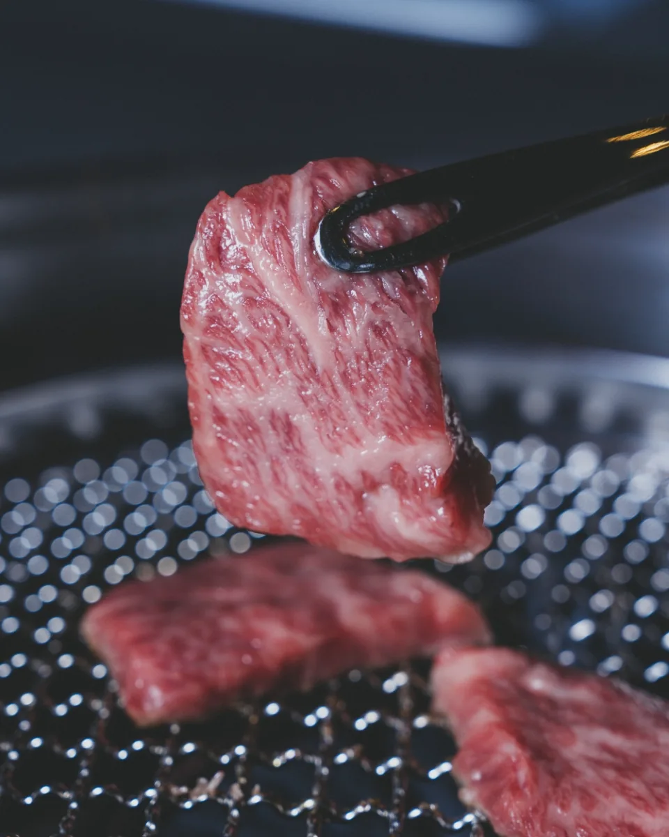 焼き網の上でトングで持ち上げた和牛